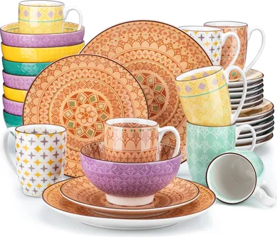 A collection of ceramic dinnerware and mugs with a bohemian-inspired pattern.