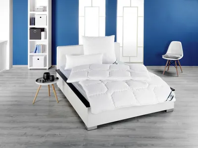 A bedroom scene with a bed, bookshelf, and chair.