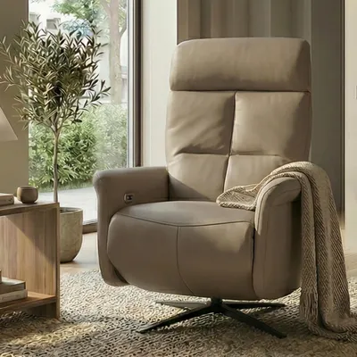 A recliner chair in a living room setting with a plant and side table.
