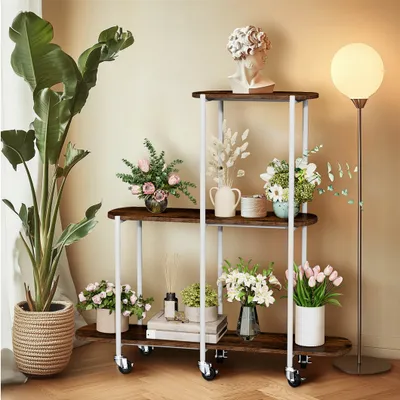 A multi-tiered plant stand filled with various plants and decorative items, placed in a room with a floor lamp.