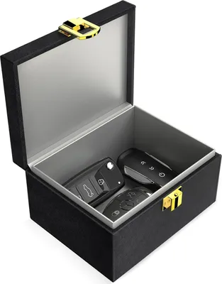 A black box with a gold latch, containing three car key fobs.