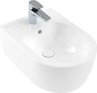 A white ceramic bidet with a chrome faucet against a white background.