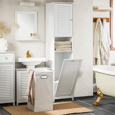 A clean and organized bathroom scene featuring a white cabinet with a laundry basket and towels.