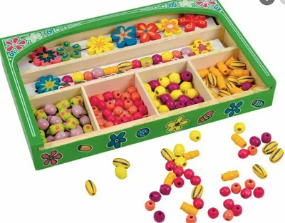 Produktbild von Woody Fädelset mit diversen bunten Holzblumen und Holzperlen mit Schnüren. Motorikspiel