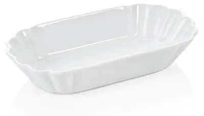 A white ceramic serving dish with a fluted edge on a white background.