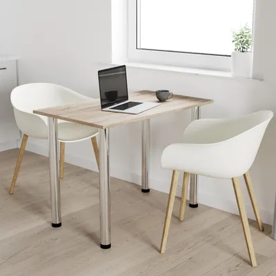 A small dining table with two chairs in a bright room with a window.