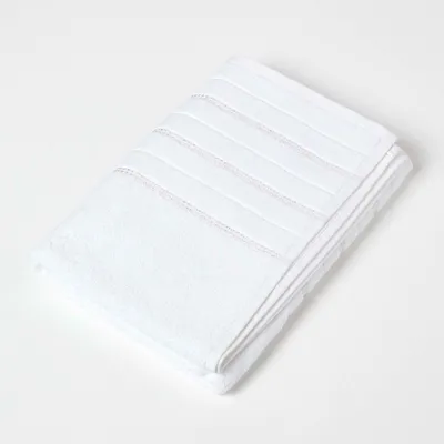 Produktbild von HOMESCAPES Weißes Duschtuch mit Glitzer-Bordüre aus 100% Baumwolle, 70 x 130 cm