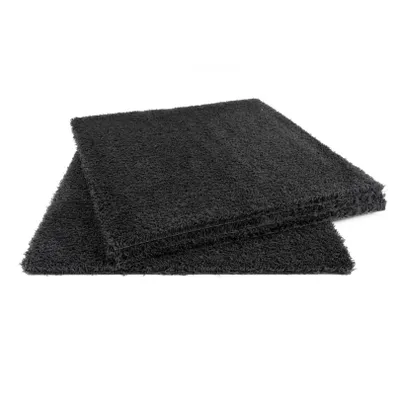 Two black carpet tiles are stacked on a white background.