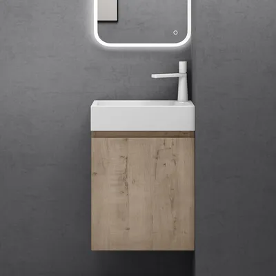 A modern bathroom vanity with a white sink and a wood-grain cabinet against a gray wall.
