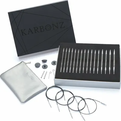 A set of knitting needles and accessories is displayed on a white background, with the product box open.