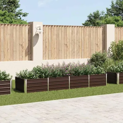 A garden scene with raised garden beds in front of a wooden fence.
