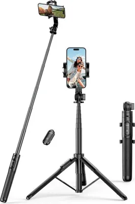 A black selfie stick with a tripod and remote control is displayed against a white background.