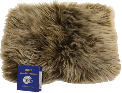 A close-up shot of a fluffy sheepskin seat cushion with a small blue tag in the bottom left corner.