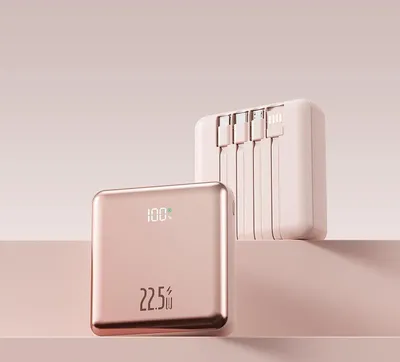 Two power banks are displayed on a pink surface against a light pink background. One power bank is in the foreground, and the other is in the background.