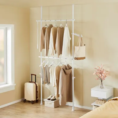 A bedroom with a clothes rack and accessories.