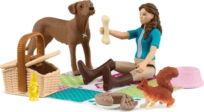 A toy picnic set with a girl, a dog, a squirrel, a picnic basket, food, and a bowl.