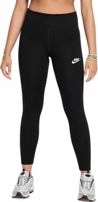 A person wearing black Nike leggings and silver sneakers, shown from the waist down against a white background.