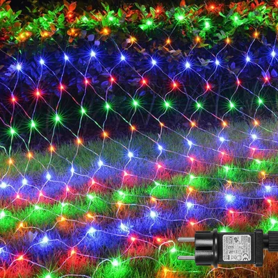 A net of colorful LED lights is draped over grass and bushes, likely for outdoor decoration.