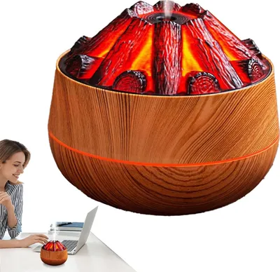 A woman is working on a laptop at a desk, with a volcano-shaped aroma diffuser emitting mist in front of her. Another, larger diffuser of the same design is visible in the background.