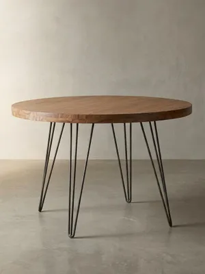 Frontalansicht des runden Design-Esstisches. Der edle Holztisch mit 120 cm Durchmesser kombiniert eine massive Sheesham-Platte mit vier mattschwarzen Metallbeinen im Industrial-Look._#sku_SAFWL5.201#