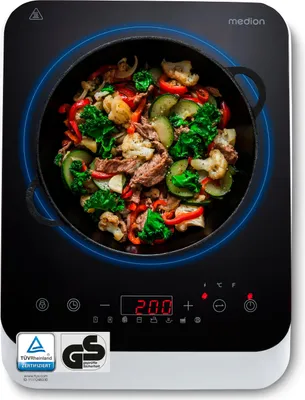 An induction cooktop with a wok full of food cooking on it.