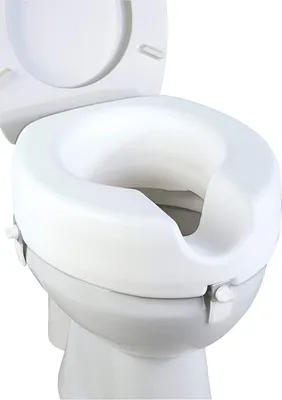A close-up, studio shot of a white toilet seat riser attached to a toilet.