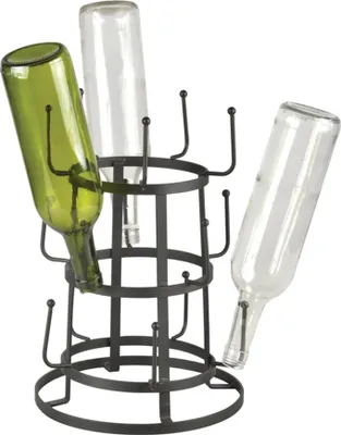 A dark metal bottle drying rack holding three bottles, one green and two clear.