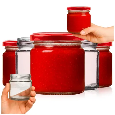 Several glass jars with red lids, some filled with a red substance, are arranged on a white background. One jar is held by a hand.