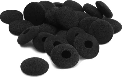A pile of black foam earphone covers on a white background.