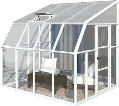 A white greenhouse with furniture inside, set on a patio.
