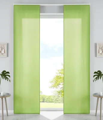Two green panel curtains are shown hanging in front of a window with a view of trees and sky.