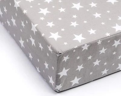 A close-up view of a grey fitted sheet with white stars, showing the corner seam.