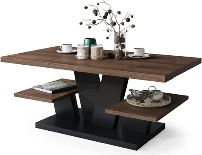 A modern coffee table with a wood-effect top and black base, decorated with a vase of branches and some decorative items.