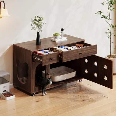 A dark wood-colored cat litter box enclosure with drawers and a cat inside, placed on a wooden floor next to a cat feeder and a plant.