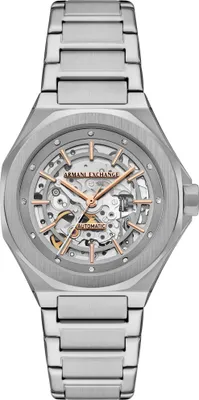 A close-up studio shot of an Armani Exchange automatic skeleton watch with a silver-tone metal bracelet and case. The watch face features rose gold-tone hands and hour markers against a skeletonized movement.
