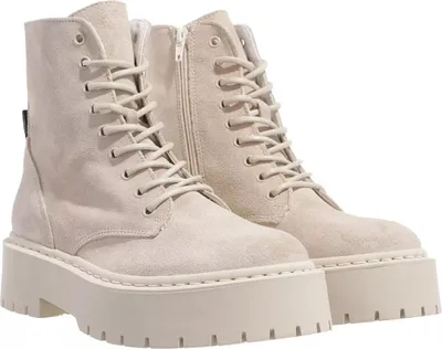 A pair of beige suede lace-up boots with thick platform soles, shown against a white background.