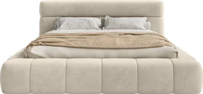 A beige upholstered bed with two pillows and a folded blanket.