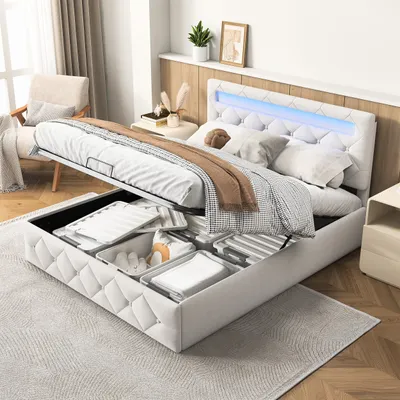 A white upholstered bed with storage drawers open, showing the interior and contents. The headboard has LED lighting.