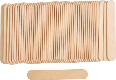 A stack of wooden popsicle sticks and one stick lying below.