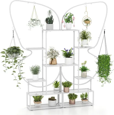 A white metal plant stand with multiple shelves and hanging hooks, filled with various potted plants.