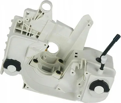 A white plastic chainsaw crankcase assembly with black caps and a black fuel line.