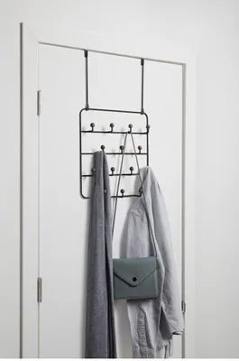 An over-the-door hook rack with a scarf, jacket, and purse hanging on it, mounted on a white door.