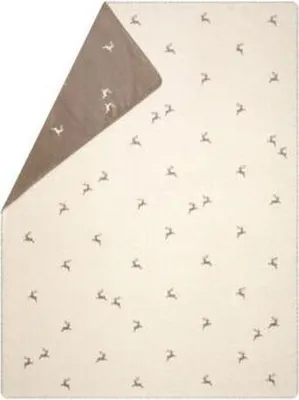 A cream-colored blanket with a pattern of small brown deer, folded to show a brown underside.