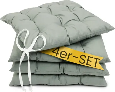 A stack of four gray seat cushions tied together with a white ribbon, with a yellow banner across the middle.