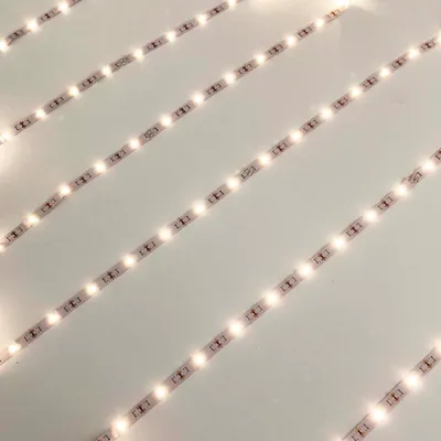 Multiple LED light strips are laid out diagonally on a white surface.