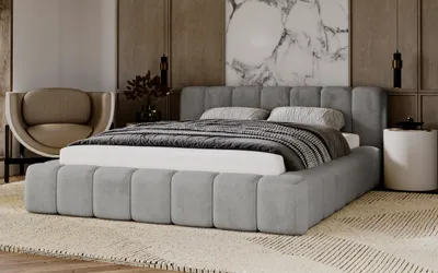 A modern bedroom setting with a large upholstered bed as the focal point.