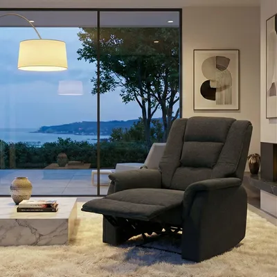 A modern living room with a recliner chair, coffee table, and a large window overlooking a scenic view.