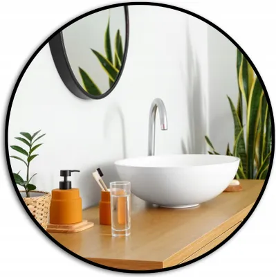 A bathroom vanity with a sink, faucet, soap dispenser, toothbrush holder, and a glass of water. Plants are visible in the background and reflected in the mirror.