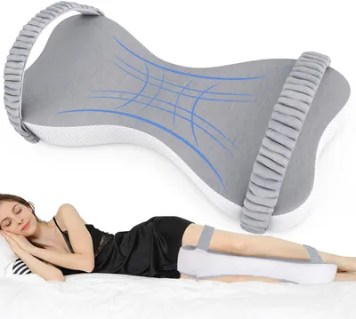A woman is sleeping on a bed with a knee pillow placed between her legs.