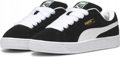 A pair of black Puma Suede XL sneakers with white laces and soles, shown from a side-angle.